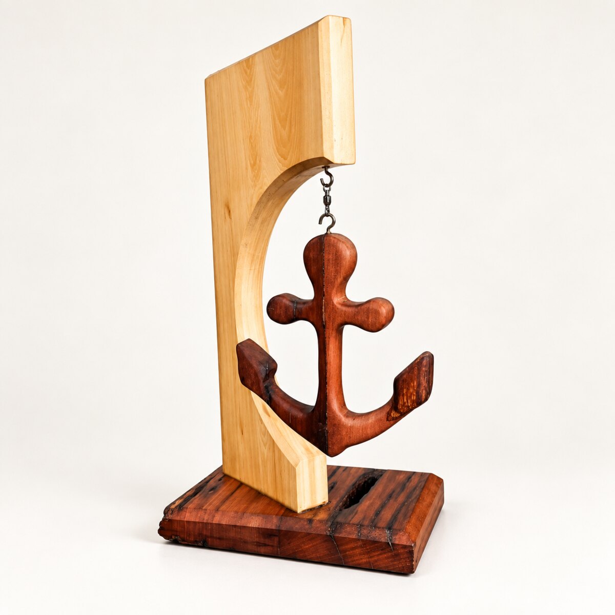 Hand-shaped timber anchor suspended in a curved frame